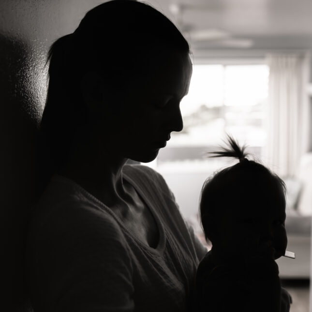 Silhouette of mother with head down embracing her child. -- health tech coverage from sTAT