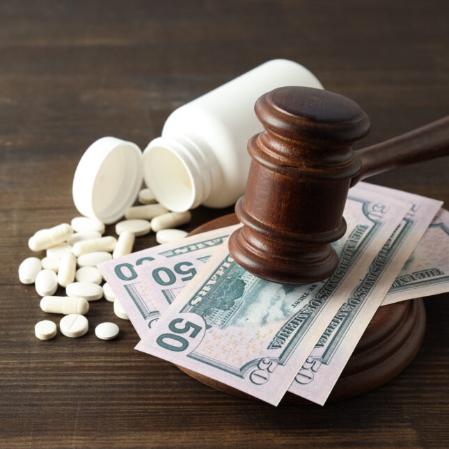 A gavel on cash next to pills spilled from a bottle — First Opinion coverage from STAT