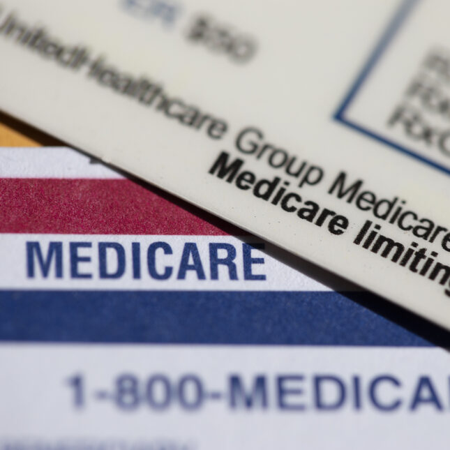 A UnitedHealthcare Group Medicare Advantage PPO card rests on top of a Medicare card. -- health policy coverage from STAT