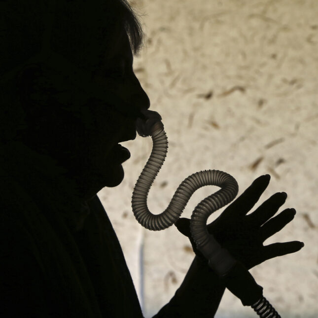 Silhouette of a person's side profile as they put on a CPAP device — health tech coverage from STAT