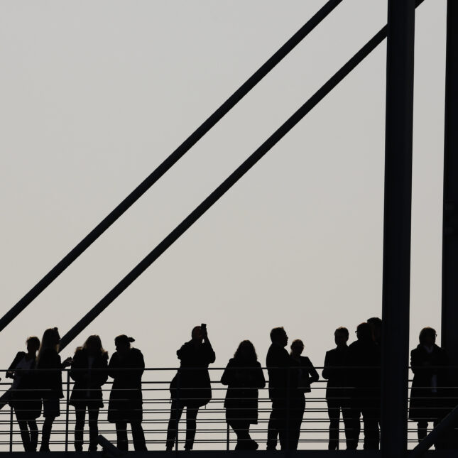 Crowd of people silhouette on a bridge. -- health coverage from STAT