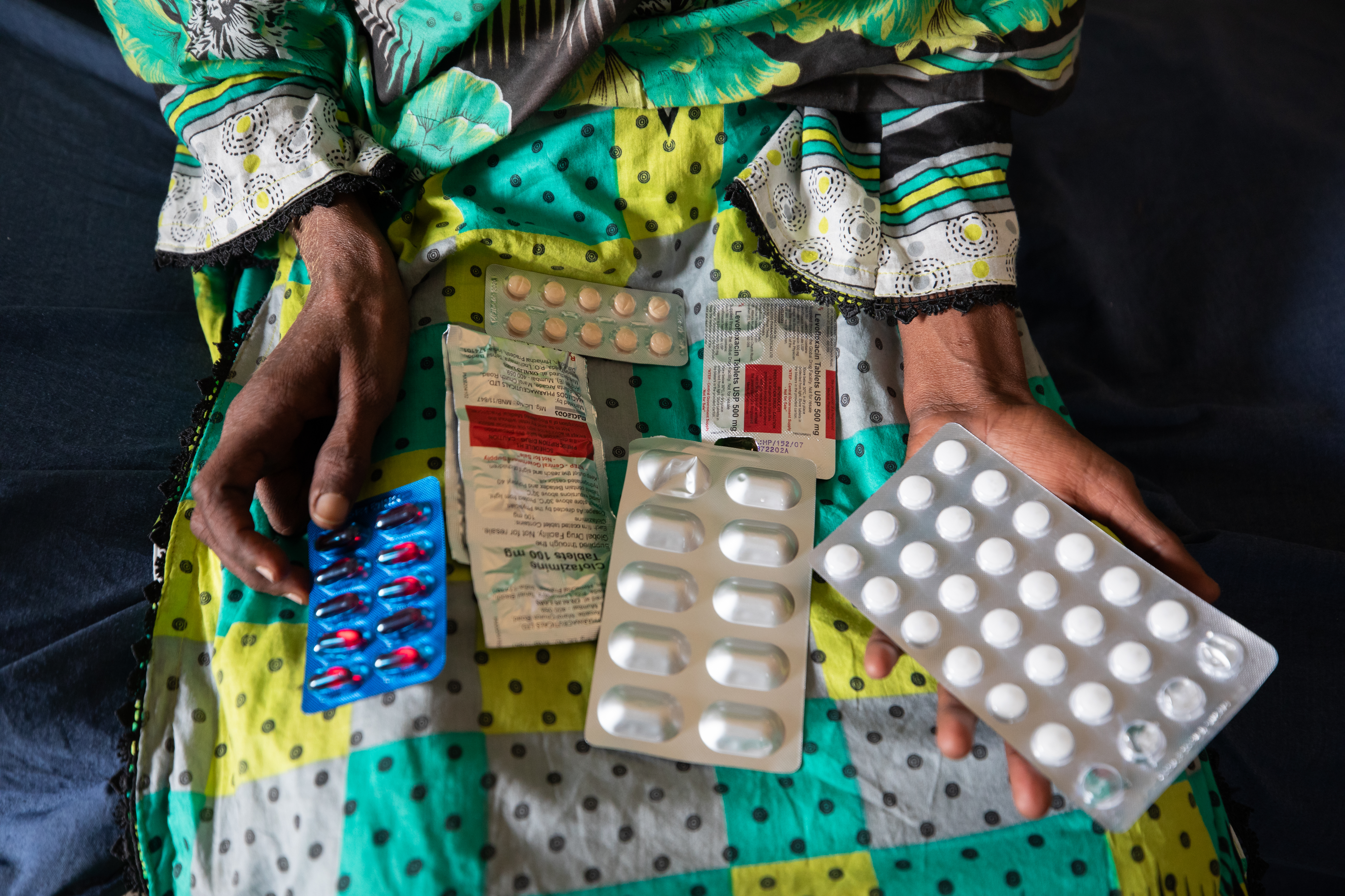 A patient holds several medications on her lap at a clinic in Pakistan. -- first option coverage from STAT