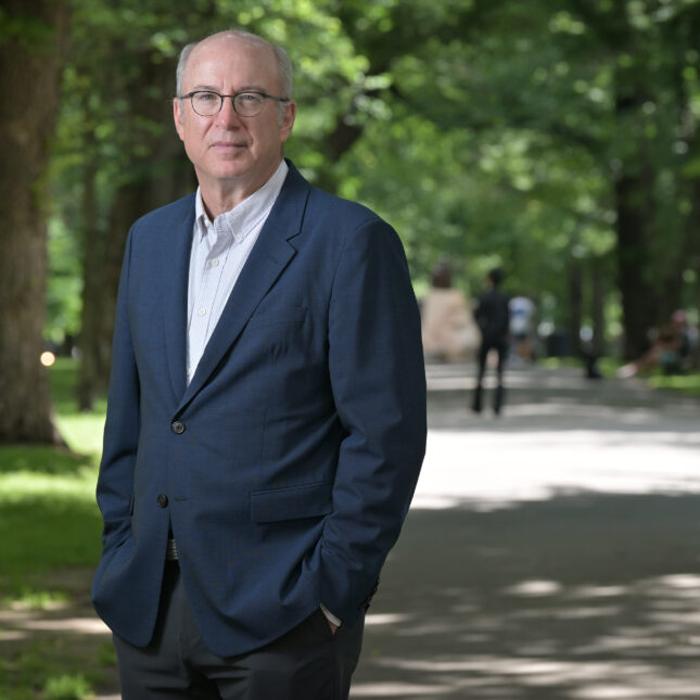 Peter Slavin, president and CEO of Ceders-Sinai Medical Center, stands for a portrait in a park wearing a dark blue suit